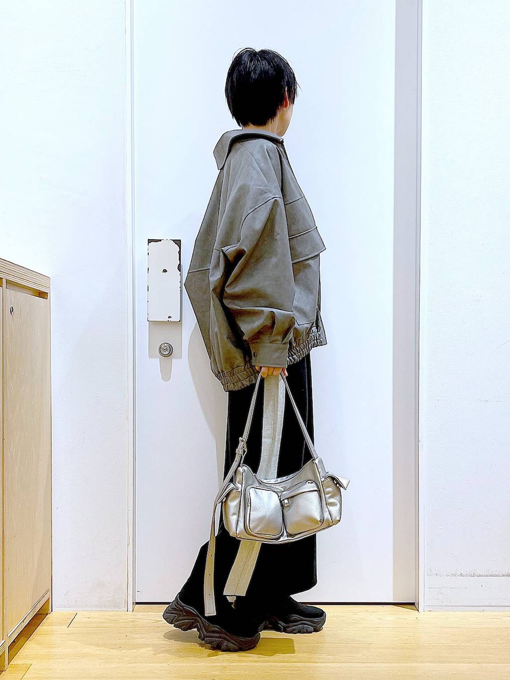 ブラック系のスカート、グレー系のブルゾン、ブラック系のブーツを着用したレディースの冬コーディネートの4枚目の写真