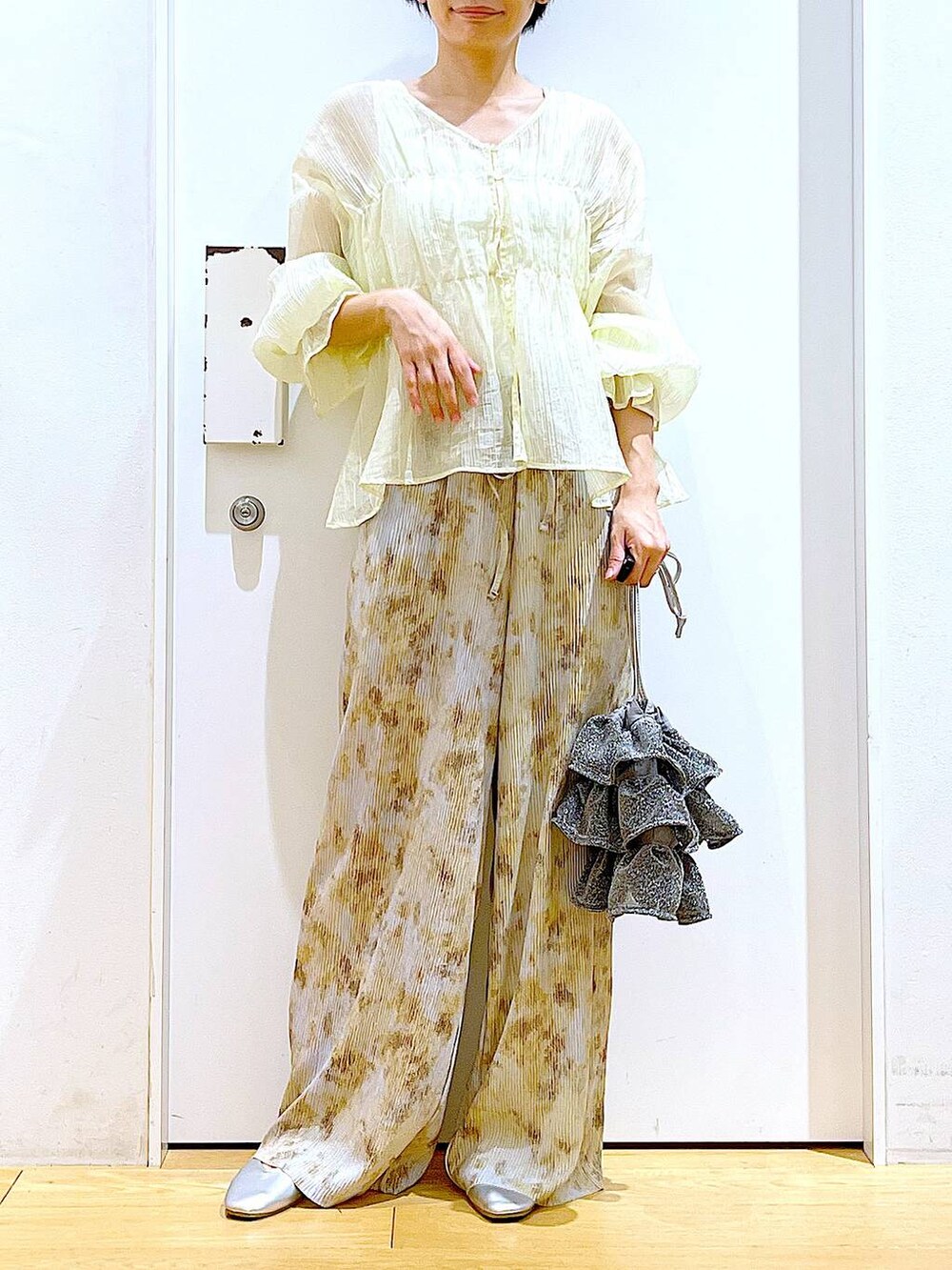 シルバー系のショルダーバッグ、シルバー系のパンプス、ベージュ系のシャツ/ブラウスを着用したレディースの夏コーディネートの6枚目の写真