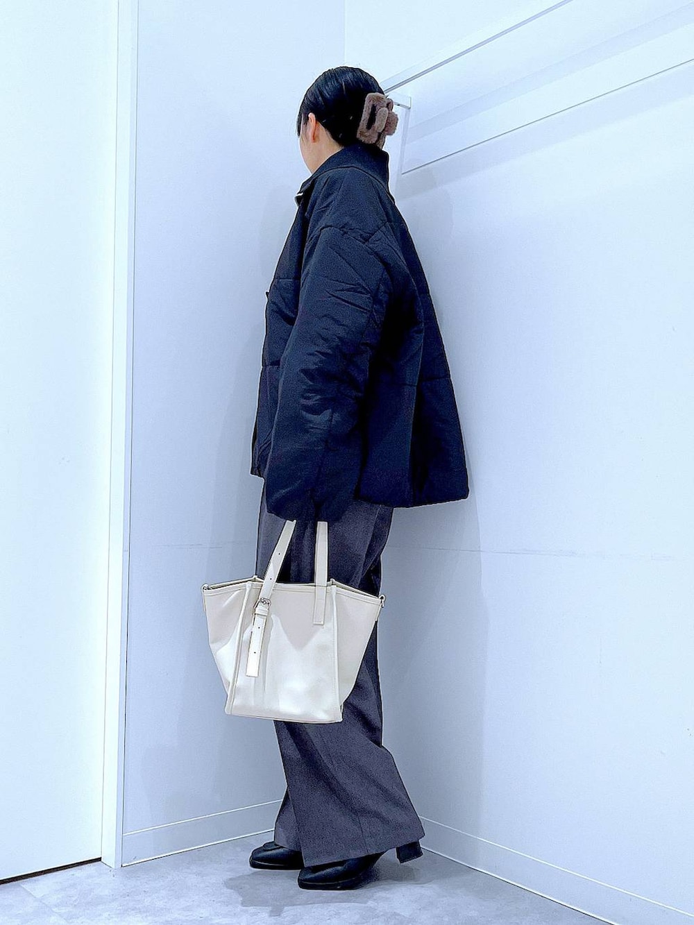 ブラック系のブルゾン、ブラック系のブーツ、グレー系のスラックスを着用したレディースの冬コーディネートの3枚目の写真