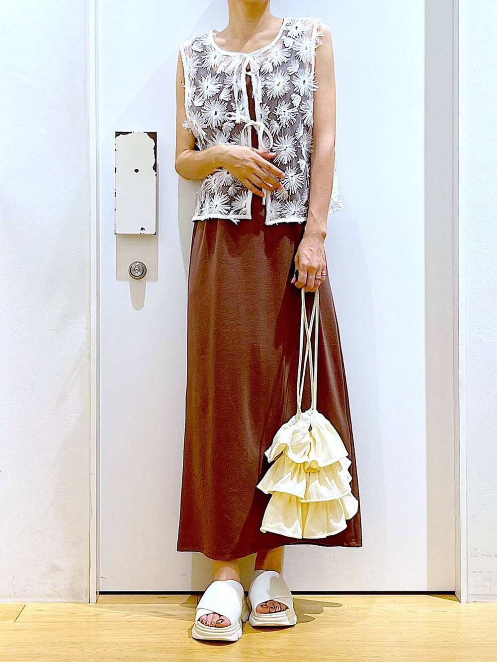 ホワイト系のサンダル、レッド系のワンピース、ホワイト系のベストを着用したレディースの夏コーディネートの6枚目の写真