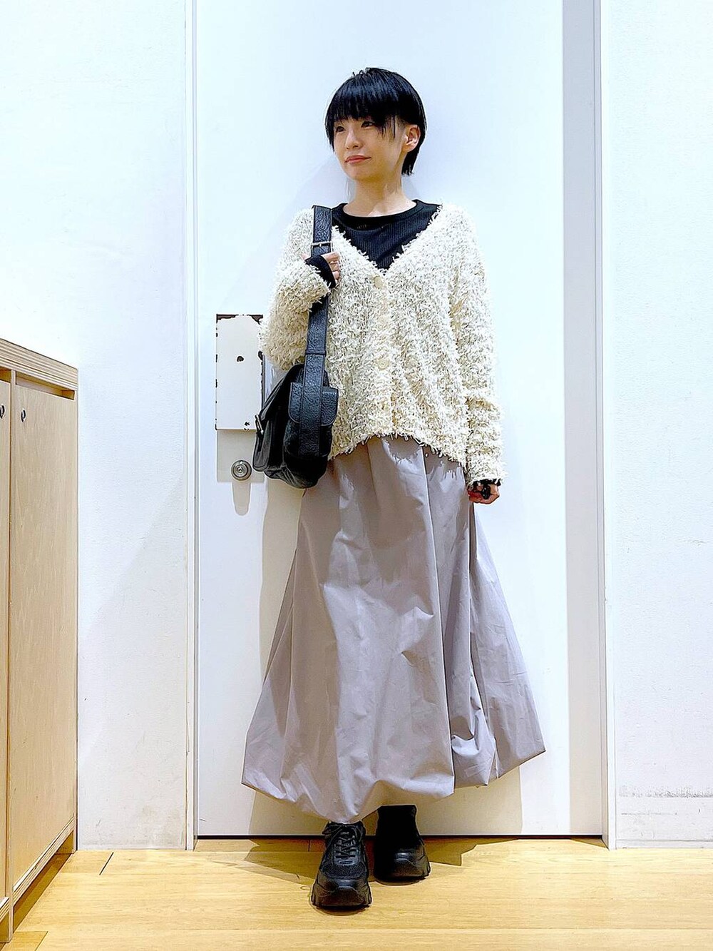 ブラック系のスニーカー、ブラック系のTシャツ/カットソー、グレー系のスカートを着用したレディースの春コーディネートの2枚目の写真