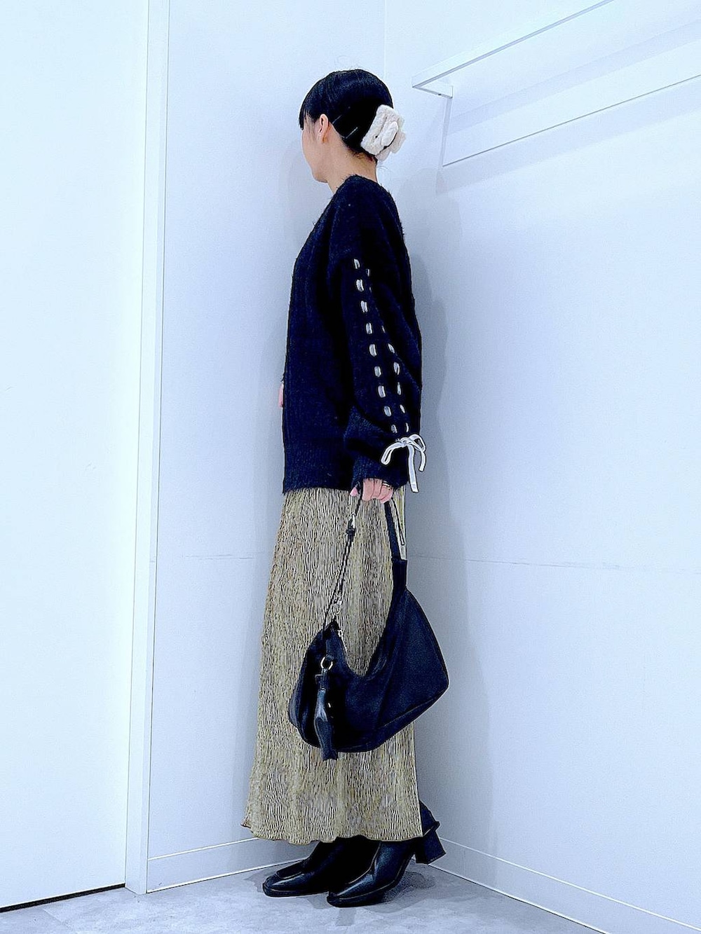 ブラック系のブーツ、ブラック系のニット/セーター、ブラック系のショルダーバッグを着用したレディースの冬コーディネートの3枚目の写真