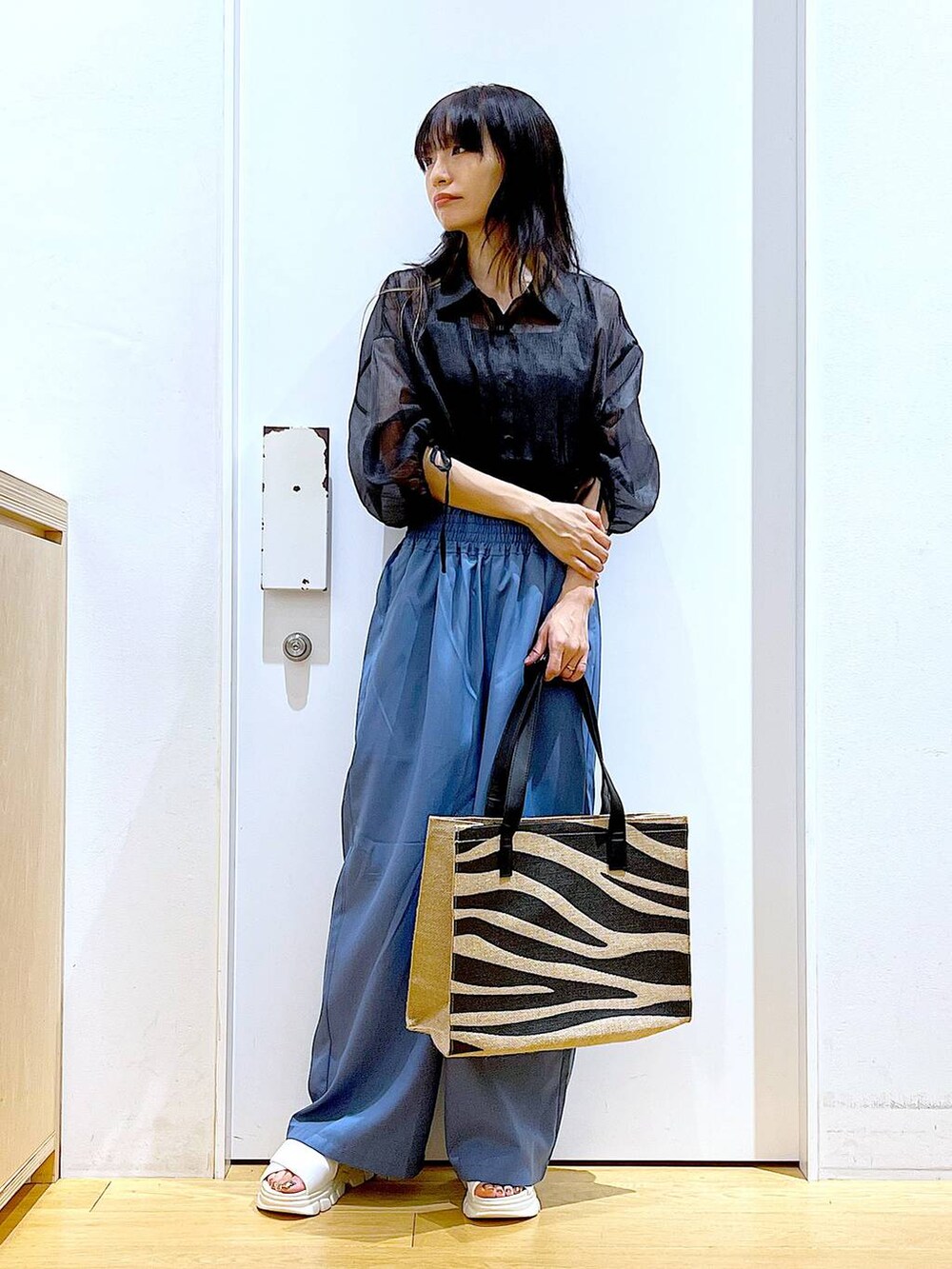 ホワイト系のサンダル、その他のトートバッグ、ブルー系のその他パンツを着用したレディースの夏コーディネートの2枚目の写真