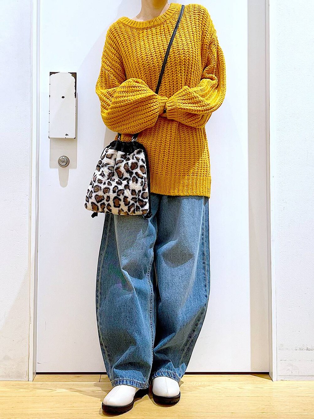 ベージュ系のブーツ、その他のショルダーバッグ、ブルー系のデニムパンツを着用したレディースの冬コーディネートの3枚目の写真