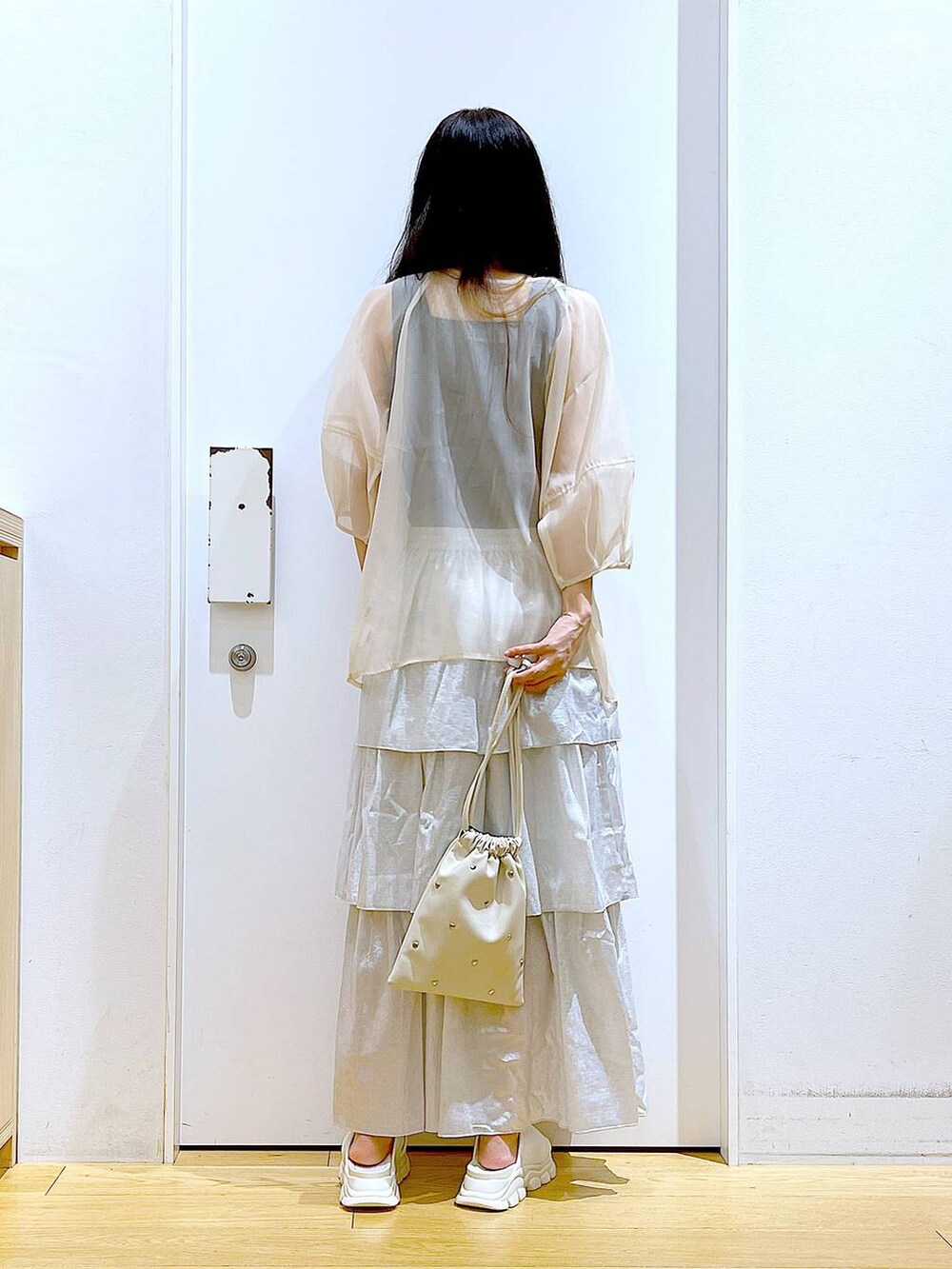 ホワイト系のサンダル、ブラック系のニット/セーター、ホワイト系のショルダーバッグを着用したレディースの夏コーディネートの4枚目の写真