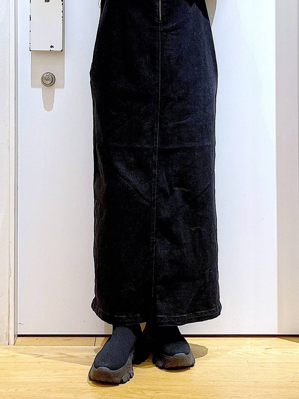 グレー系のジャンパースカート、グレー系のショルダーバッグ、ブラック系のブーツを着用したレディースの冬コーディネートの8枚目の写真