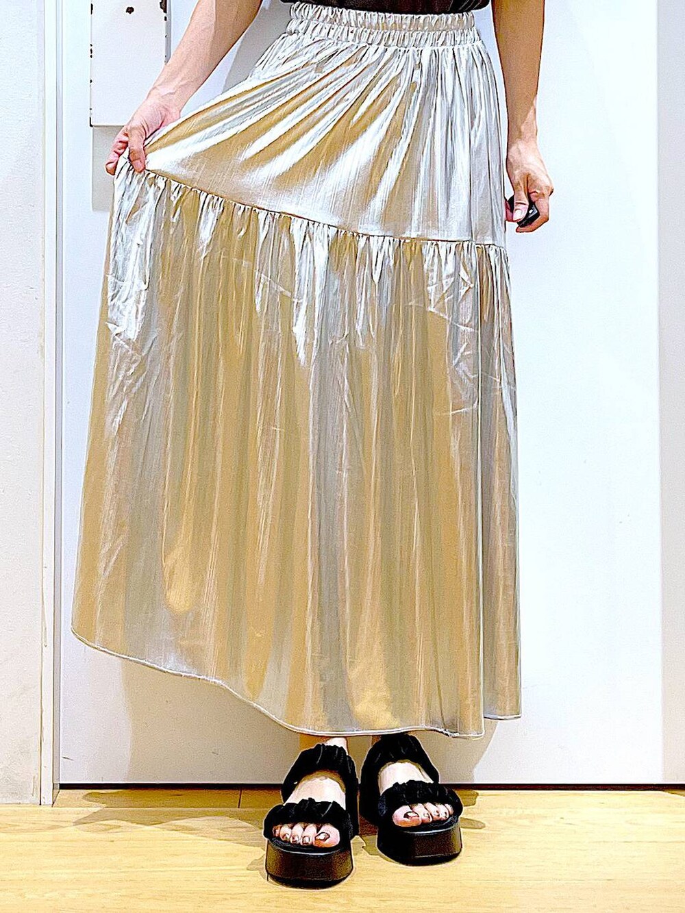 ブラック系のサンダル、シルバー系のスカート、ブルー系のトートバッグを着用したレディースの夏コーディネートの8枚目の写真