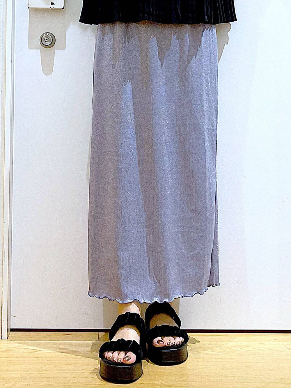 パープル系のスカート、ブラック系のショルダーバッグ、ブラック系のサンダルを着用したレディースの夏コーディネートの8枚目の写真