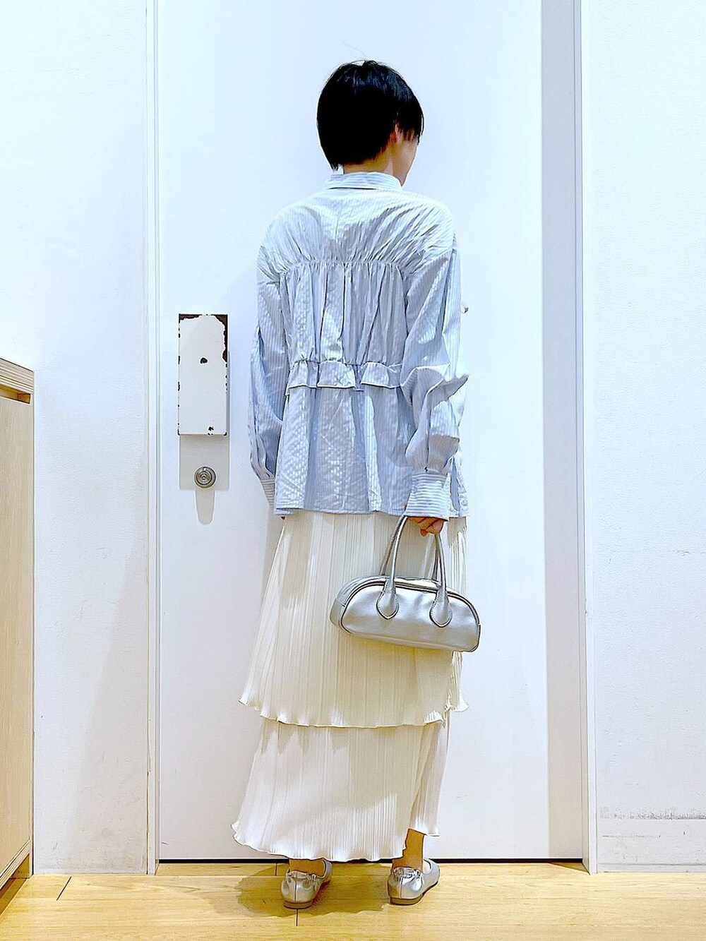 シルバー系のボストンバッグ、シルバー系のパンプス、ブルー系のシャツ/ブラウスを着用したレディースの春コーディネートの5枚目の写真