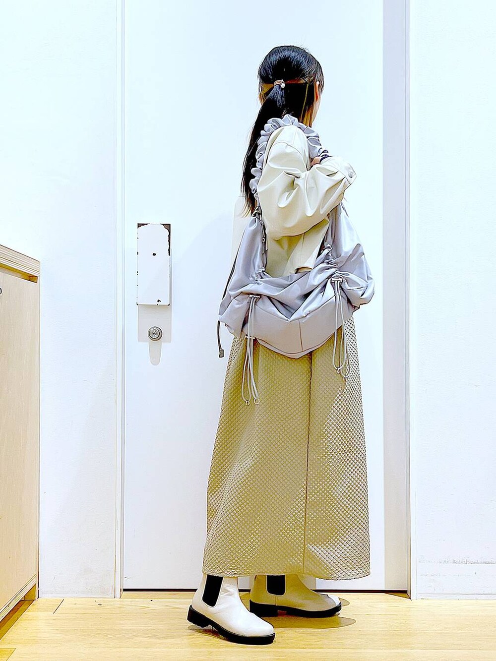 ベージュ系のブルゾン、ブラウン系のワンピース、ブルー系のTシャツ/カットソーを着用したレディースの春コーディネートの4枚目の写真