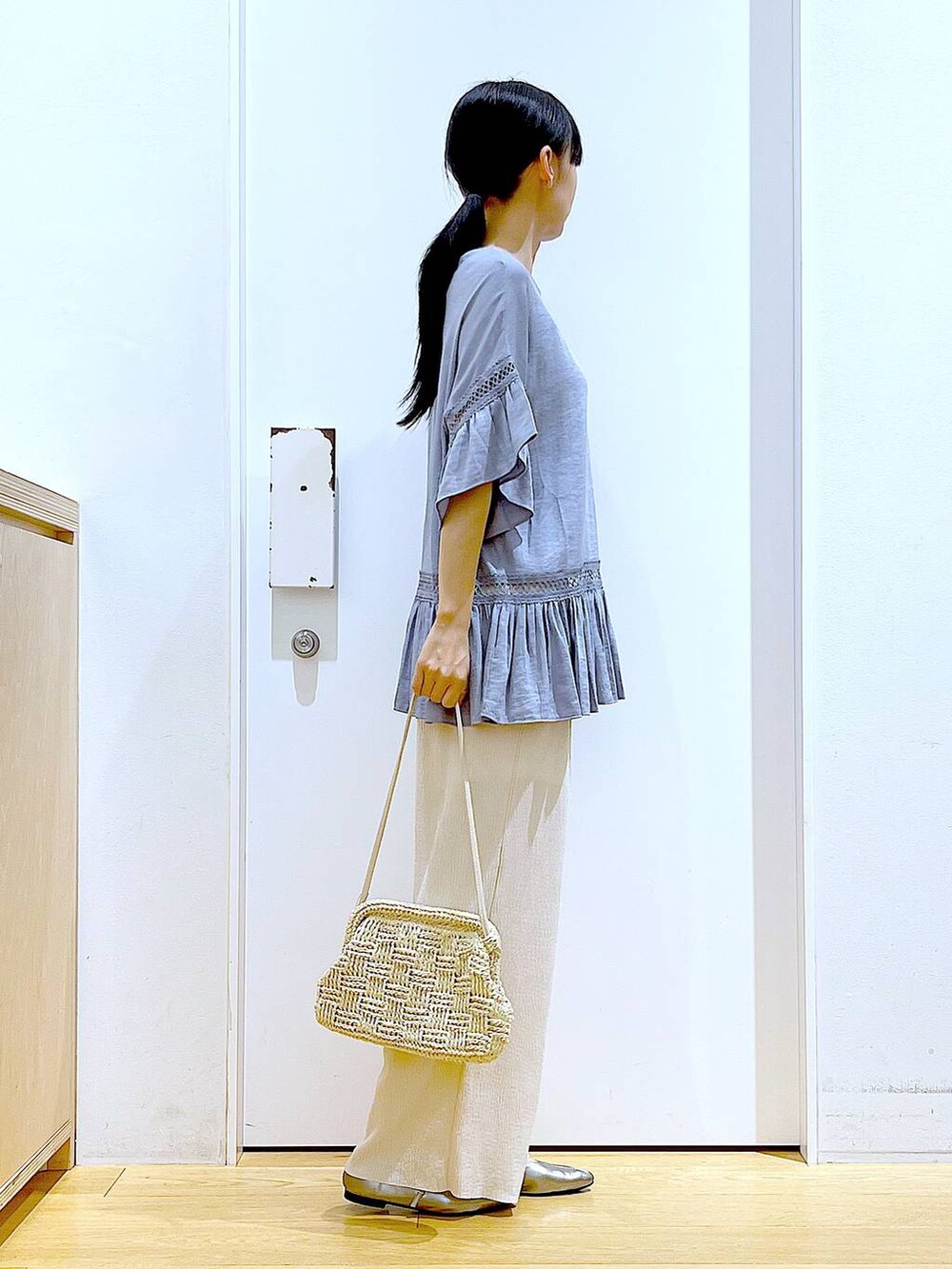 ブルー系のチュニック、その他のパンプス、ホワイト系のショルダーバッグを着用したレディースの春コーディネートの4枚目の写真