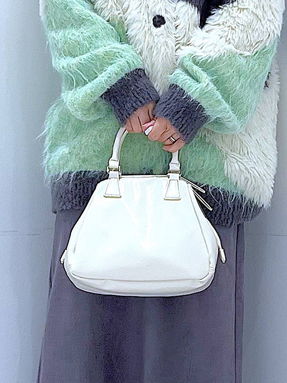 グリーン系のカーディガン/ボレロ、ブラック系のブーツ、ホワイト系のショルダーバッグを着用したレディースの冬コーディネートの9枚目の写真