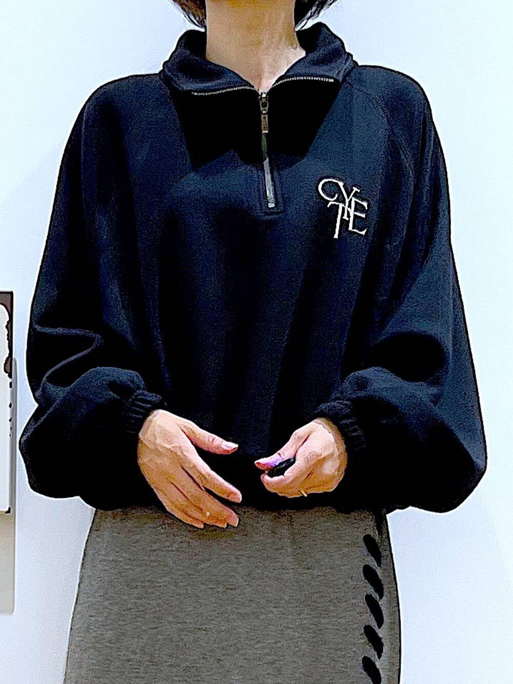 ブラック系のハンドバッグ、ブラック系のブーツ、グレー系のスカートを着用したレディースの冬コーディネートの7枚目の写真