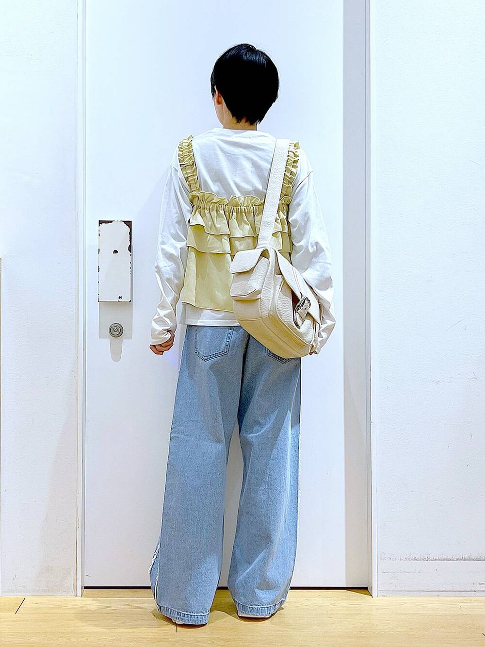 ホワイト系のスニーカー、ブルー系のデニムパンツ、ベージュ系のその他トップスを着用したレディースの春コーディネートの5枚目の写真