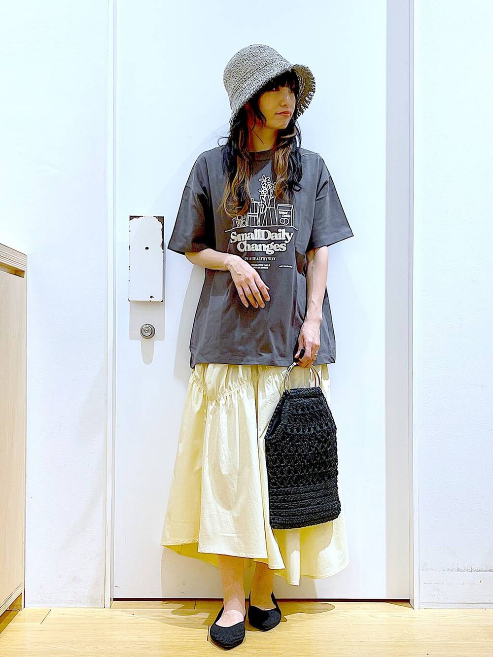 ブラック系のパンプス、グレー系のTシャツ/カットソー、ブラック系のハンドバッグを着用したレディースの春コーディネートの2枚目の写真