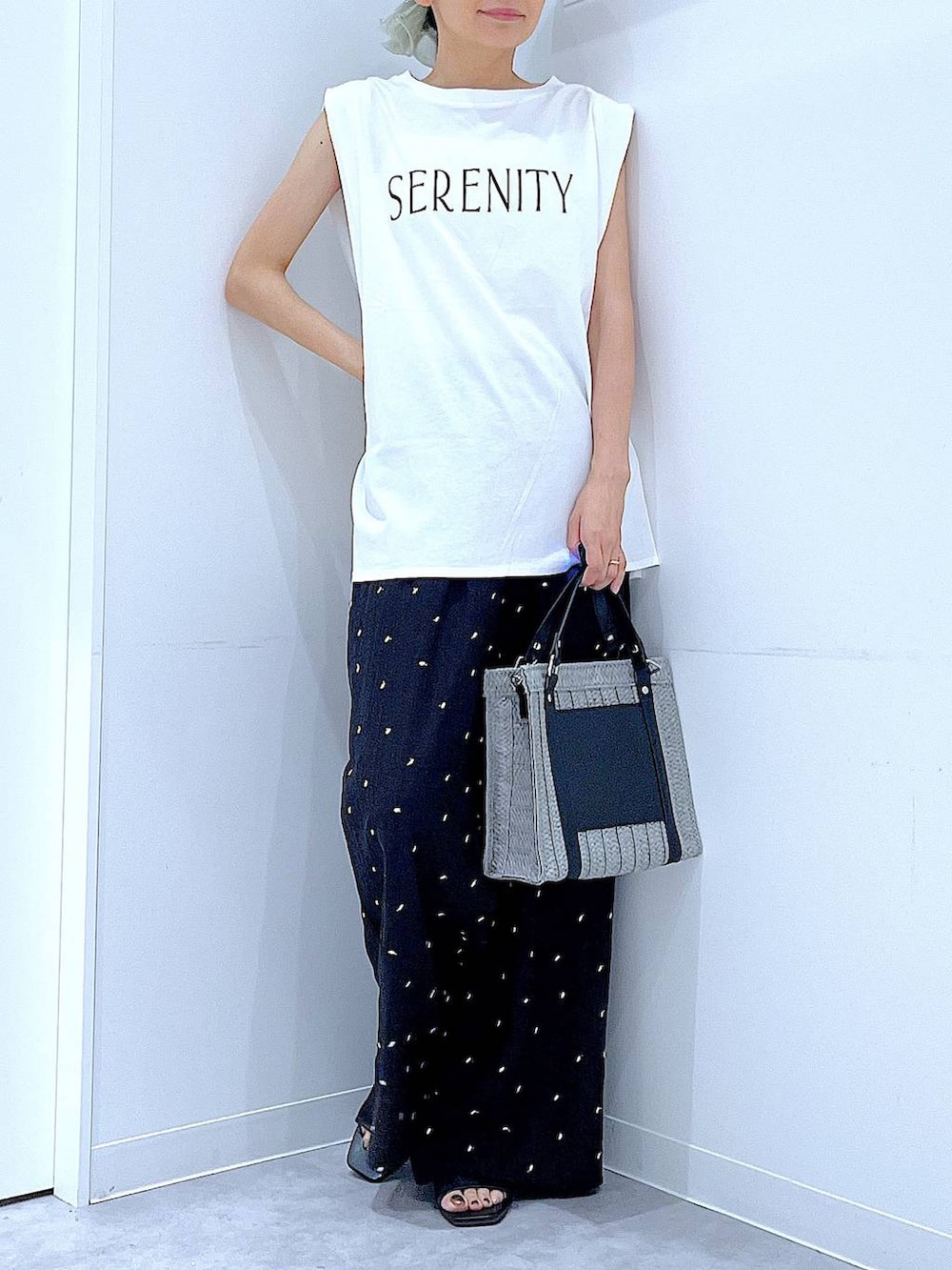 グレー系のショルダーバッグ、ブラック系のサンダル、ホワイト系のTシャツ/カットソーを着用したレディースの夏コーディネートの6枚目の写真