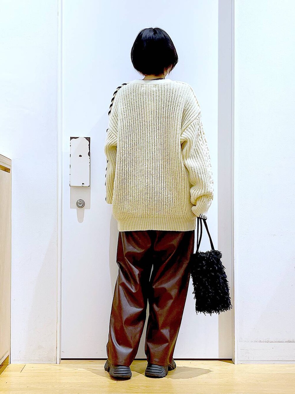 ブラック系のショルダーバッグ、グレー系のTシャツ/カットソー、ブラック系のブーツを着用したレディースの秋コーディネートの5枚目の写真