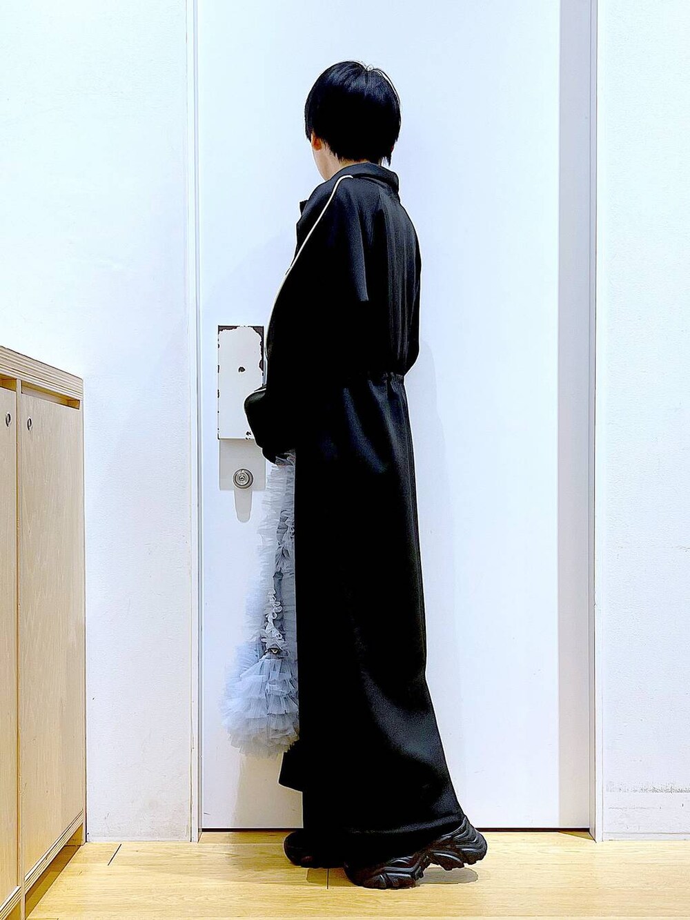 ブラック系のブーツ、ブルー系のショルダーバッグ、ブルー系のニット/セーターを着用したレディースの冬コーディネートの3枚目の写真