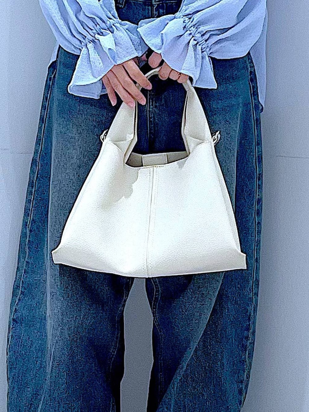 ブルー系のデニムパンツ、ベージュ系のローファー、ホワイト系のトートバッグを着用したレディースの春コーディネートの9枚目の写真