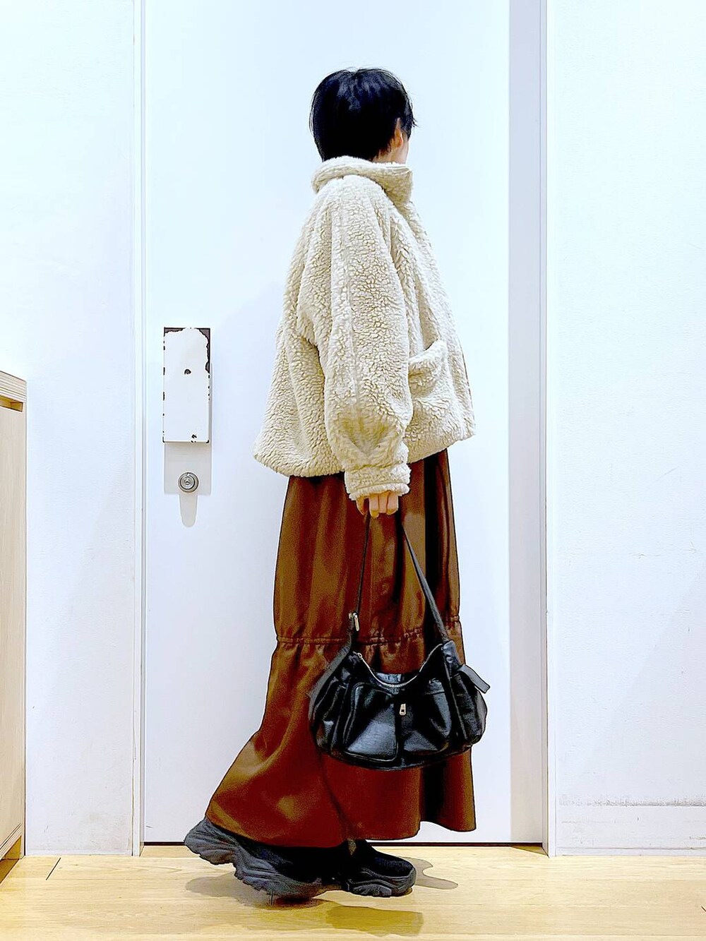 ホワイト系のブルゾン、ホワイト系のスウェット、ブラック系のブーツを着用したレディースの冬コーディネートの4枚目の写真