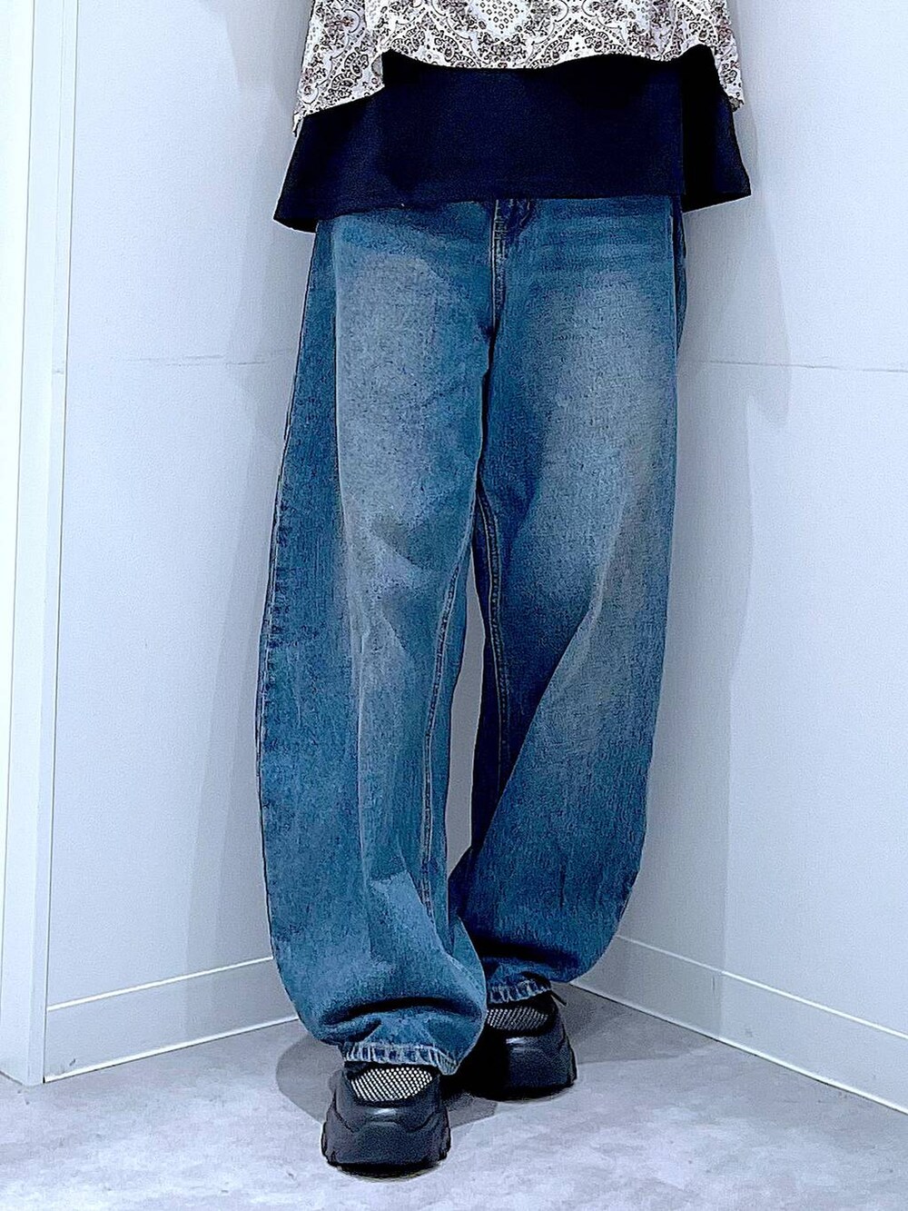 ブルー系のデニムパンツ、ブラック系のスニーカー、ブラック系のTシャツ/カットソーを着用したレディースの春コーディネートの8枚目の写真