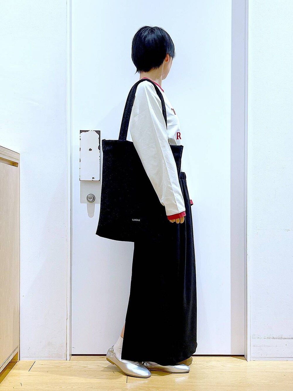 ブラック系のトートバッグ、シルバー系のパンプス、ブラック系のスカートを着用したレディースの春コーディネートの4枚目の写真