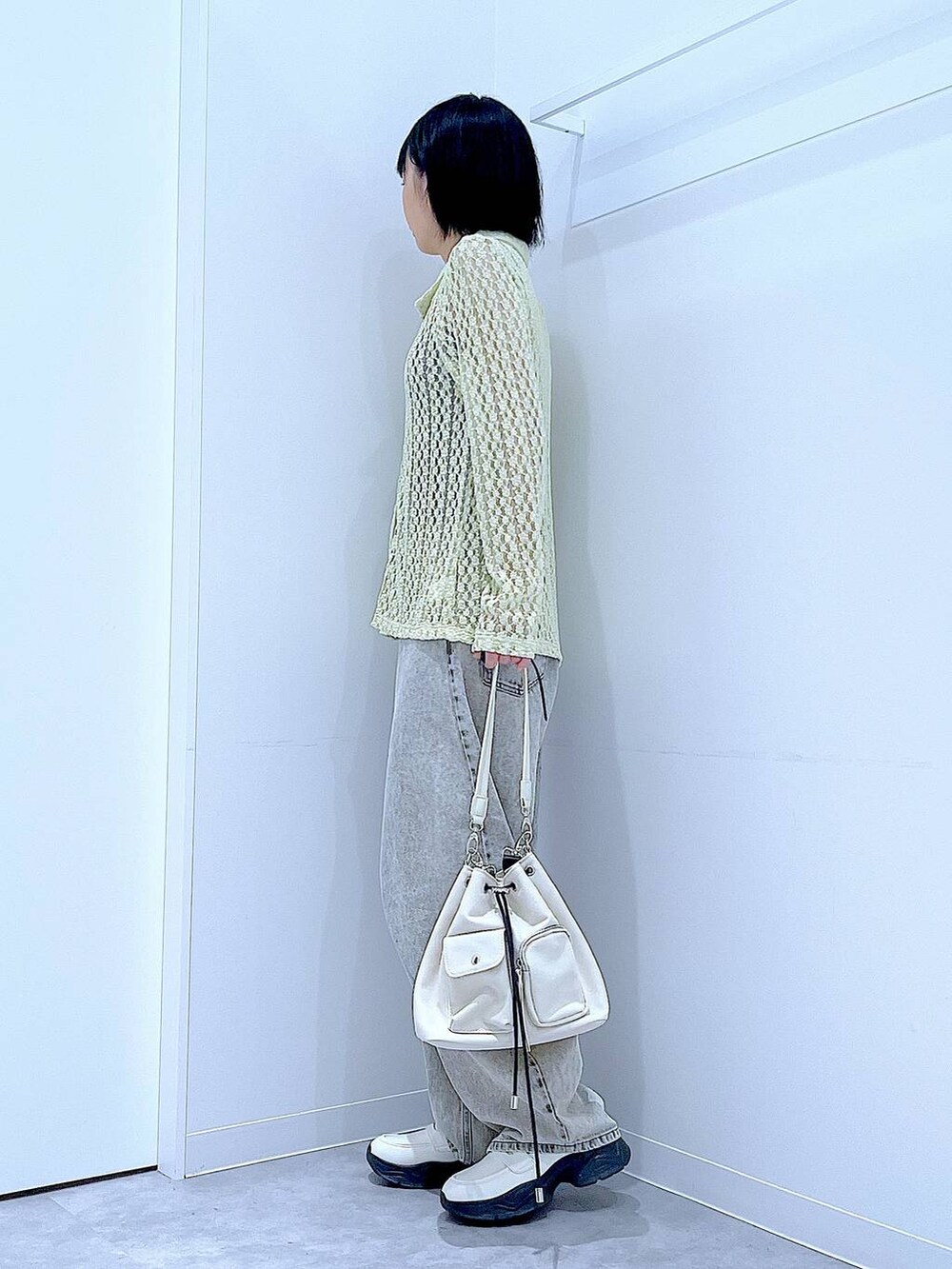 ベージュ系のデニムパンツ、ホワイト系のローファー、ホワイト系のショルダーバッグを着用したレディースの秋コーディネートの3枚目の写真
