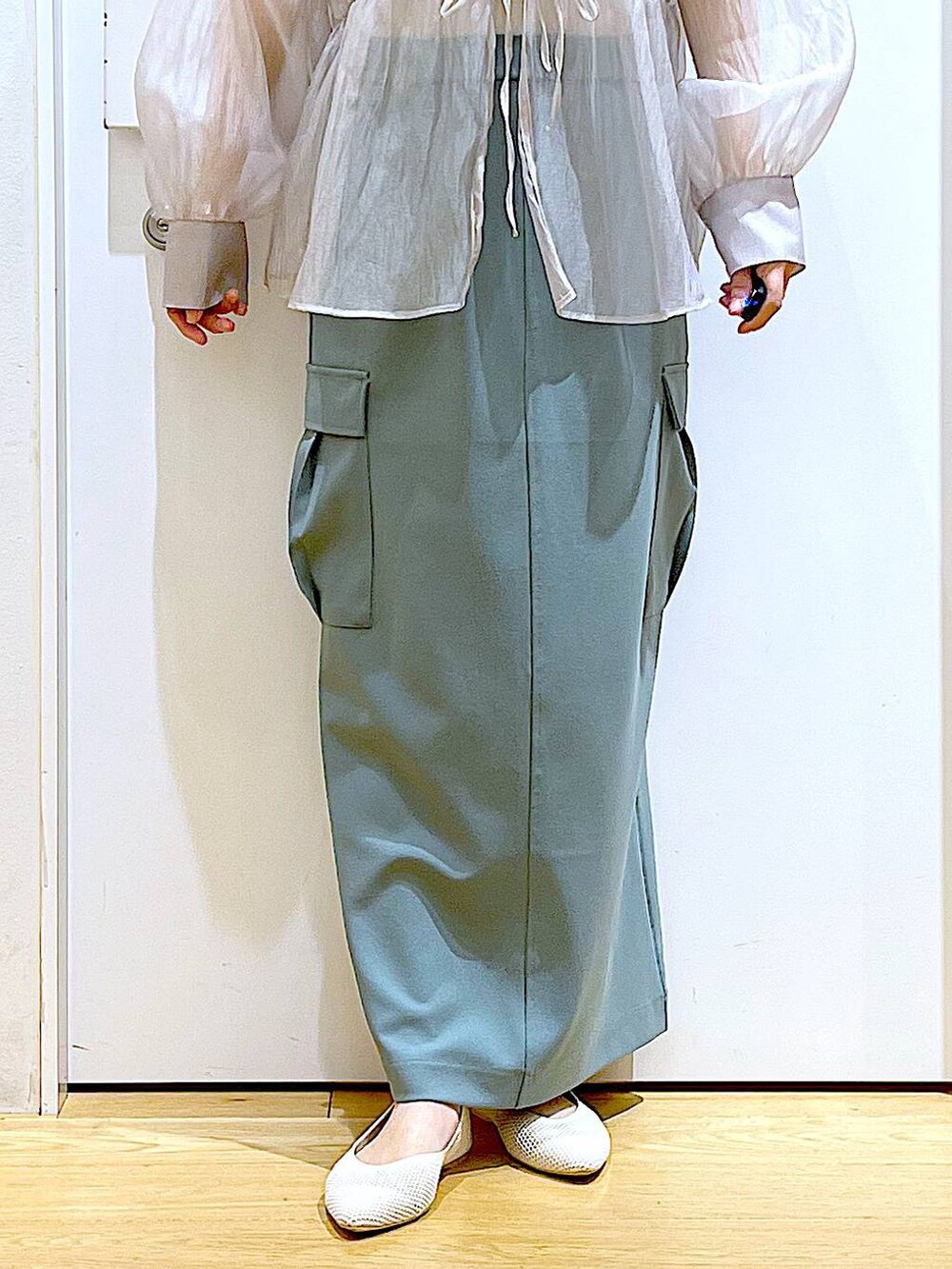 シルバー系のショルダーバッグ、グレー系のシャツ/ブラウス、ホワイト系のパンプスを着用したレディースの春コーディネートの8枚目の写真