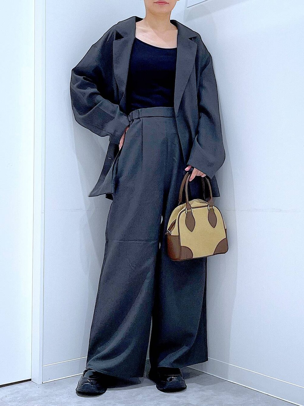 ブラック系のローファー、ベージュ系のハンドバッグ、グレー系のテーラードジャケットを着用したレディースの秋コーディネートの6枚目の写真