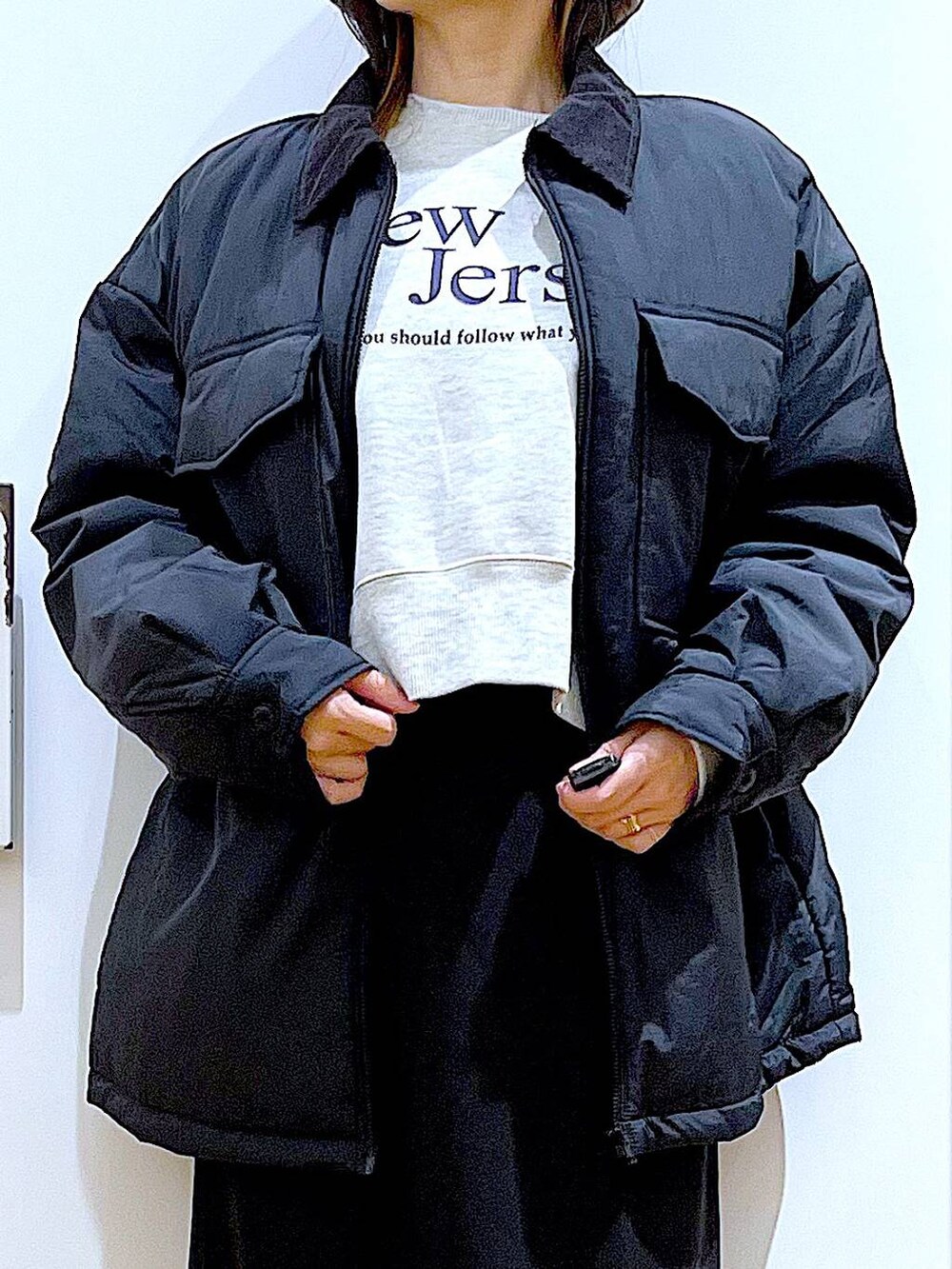 ブラック系のブルゾン、ブラック系のブーツ、ブラウン系のクラッチバッグを着用したレディースの冬コーディネートの7枚目の写真