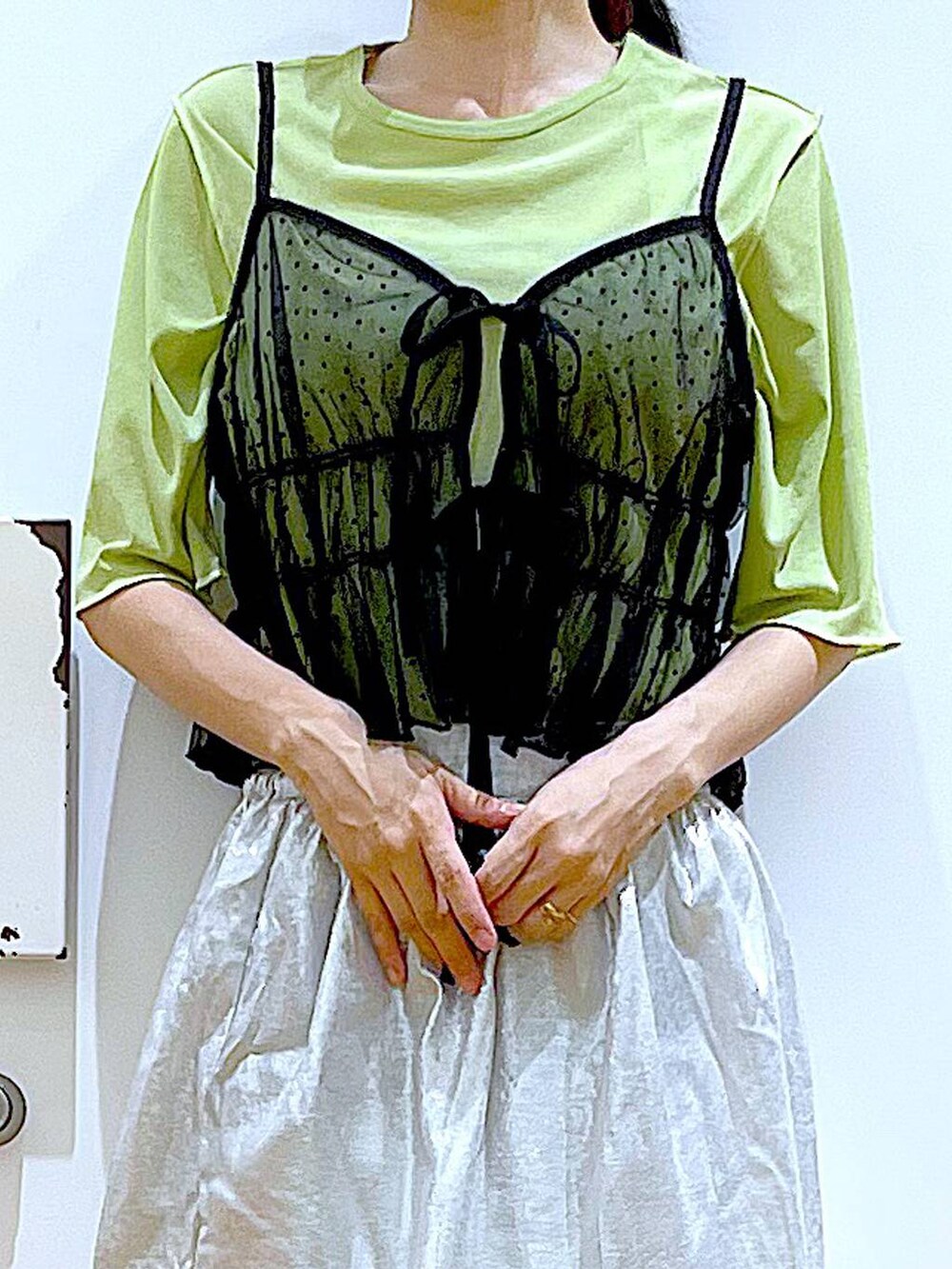 ブラック系のキャミソール、ブラック系のショルダーバッグ、ブラック系のサンダルを着用したレディースの夏コーディネートの7枚目の写真