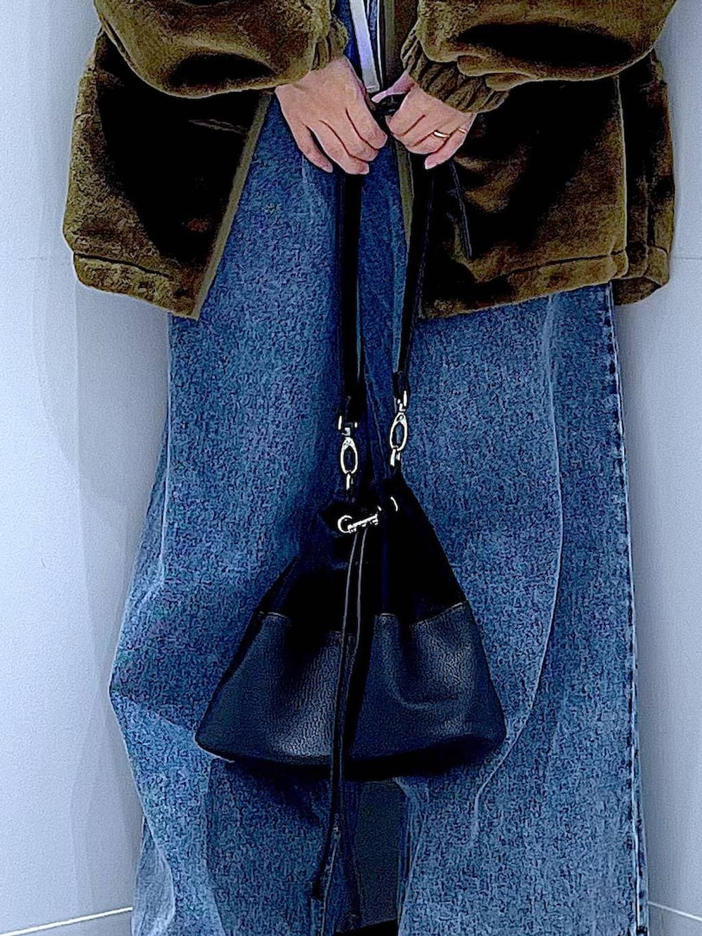 グリーン系のブルゾン、その他のニット/セーター、ブルー系のデニムパンツを着用したレディースの冬コーディネートの9枚目の写真