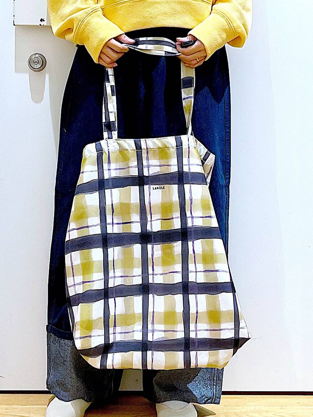 ホワイト系のパンプス、ブルー系のデニムパンツ、その他のトートバッグを着用したレディースの冬コーディネートの9枚目の写真