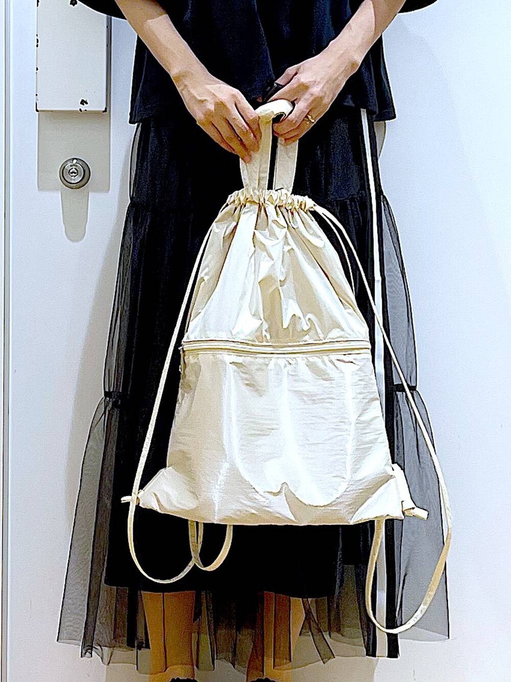 ホワイト系のバックパック/リュック、ブラック系のサンダル、ブラック系のスカートを着用したレディースの夏コーディネートの9枚目の写真