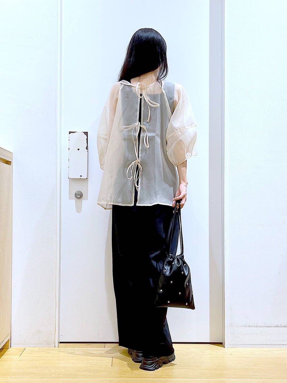 ブラック系のサンダル、ブラック系のニット/セーター、ブラック系のショルダーバッグを着用したレディースの夏コーディネートの5枚目の写真