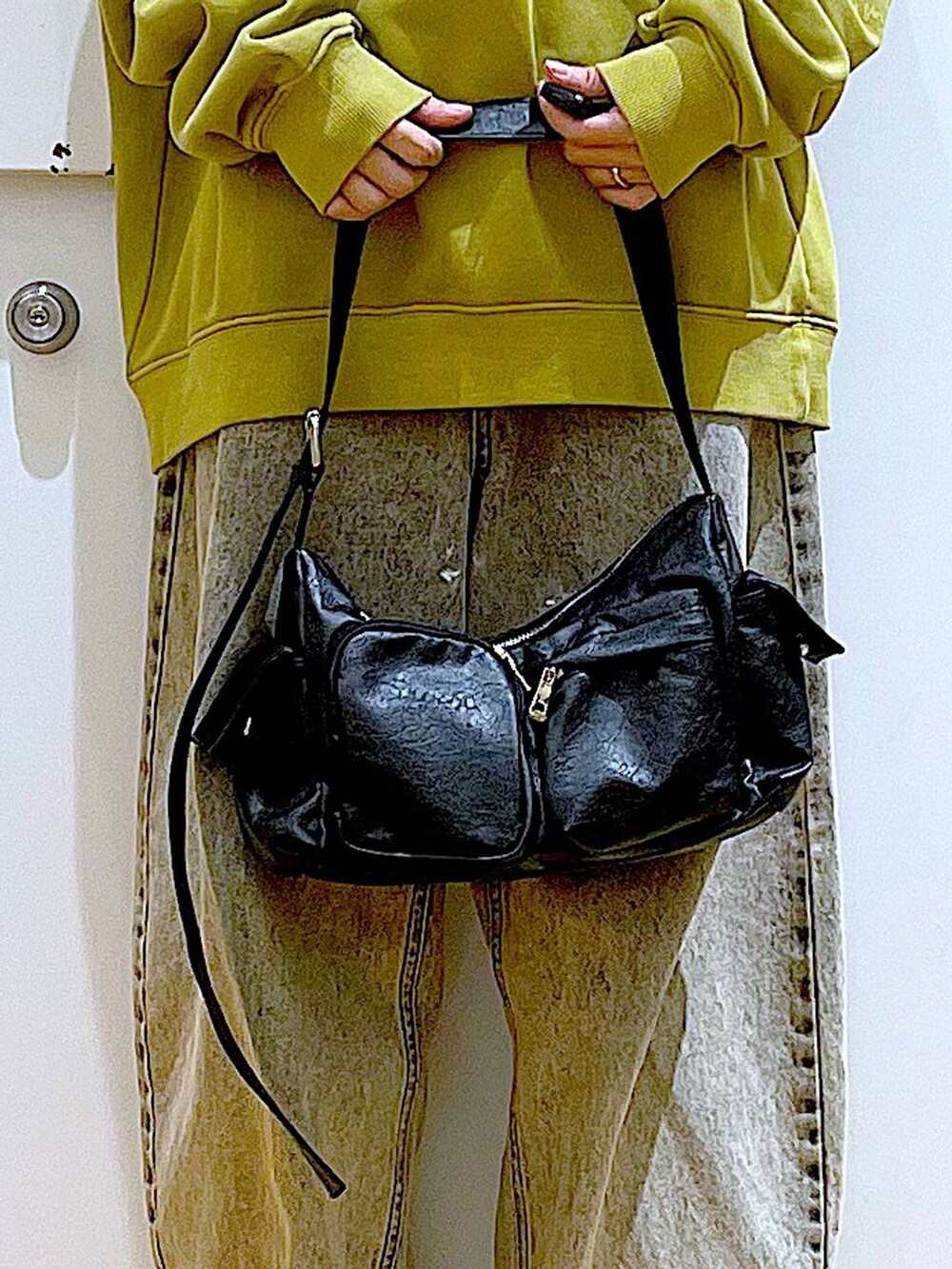 ブラック系のブーツ、ブラック系のショルダーバッグ、ベージュ系のデニムパンツを着用したレディースの冬コーディネートの9枚目の写真