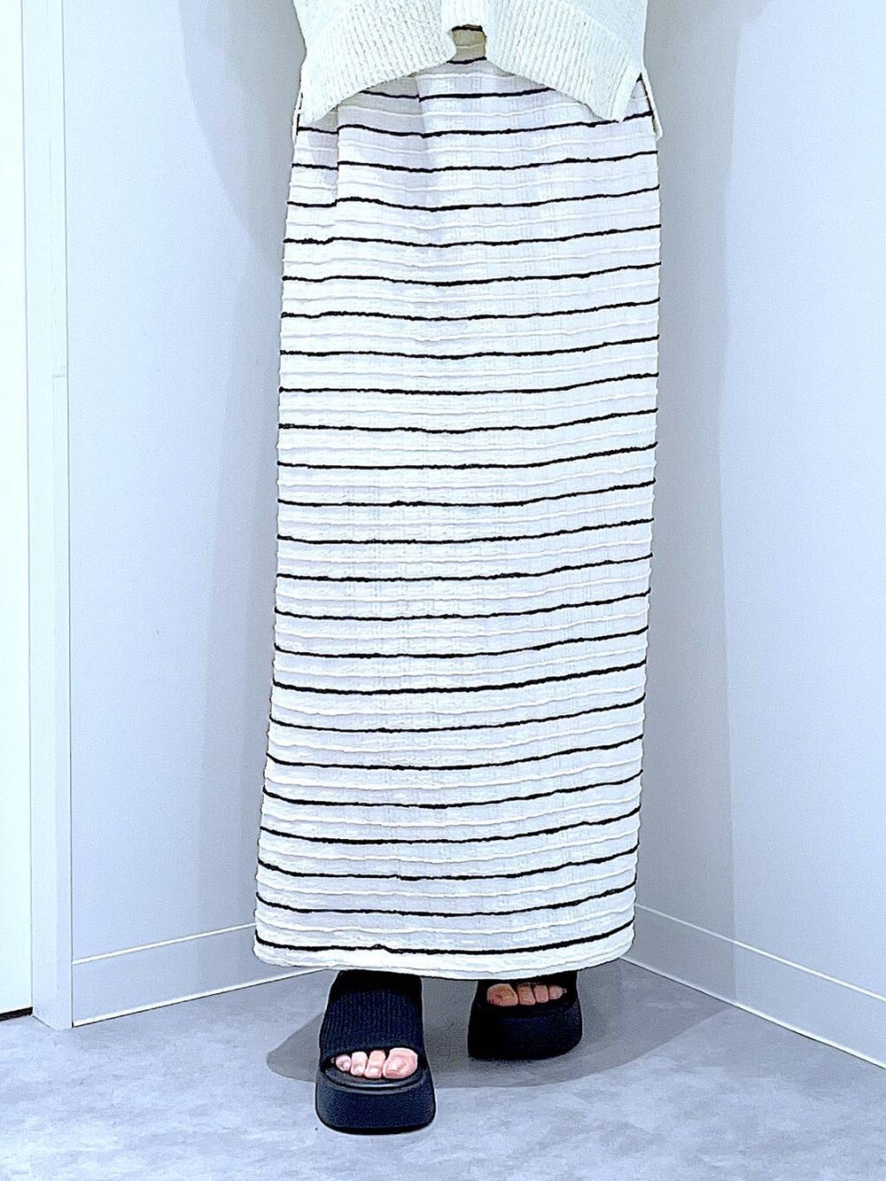 ブラック系のサンダル、イエロー系のショルダーバッグ、ホワイト系のスカートを着用したレディースの夏コーディネートの8枚目の写真