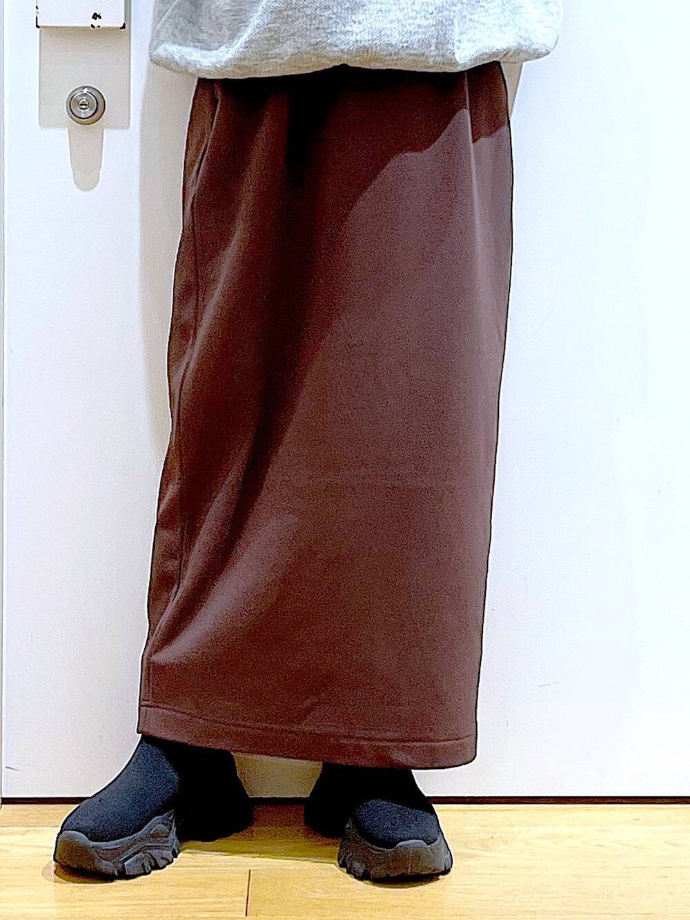 ブラック系のブーツ、ピンク系のトートバッグ、ブラウン系のスカートを着用したレディースの冬コーディネートの8枚目の写真