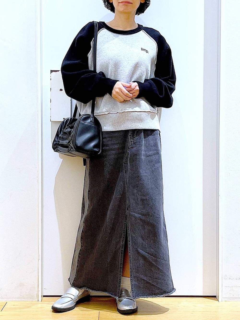 シルバー系のローファー、ブラック系のニット/セーター、ブラック系のショルダーバッグを着用したレディースの冬コーディネートの6枚目の写真