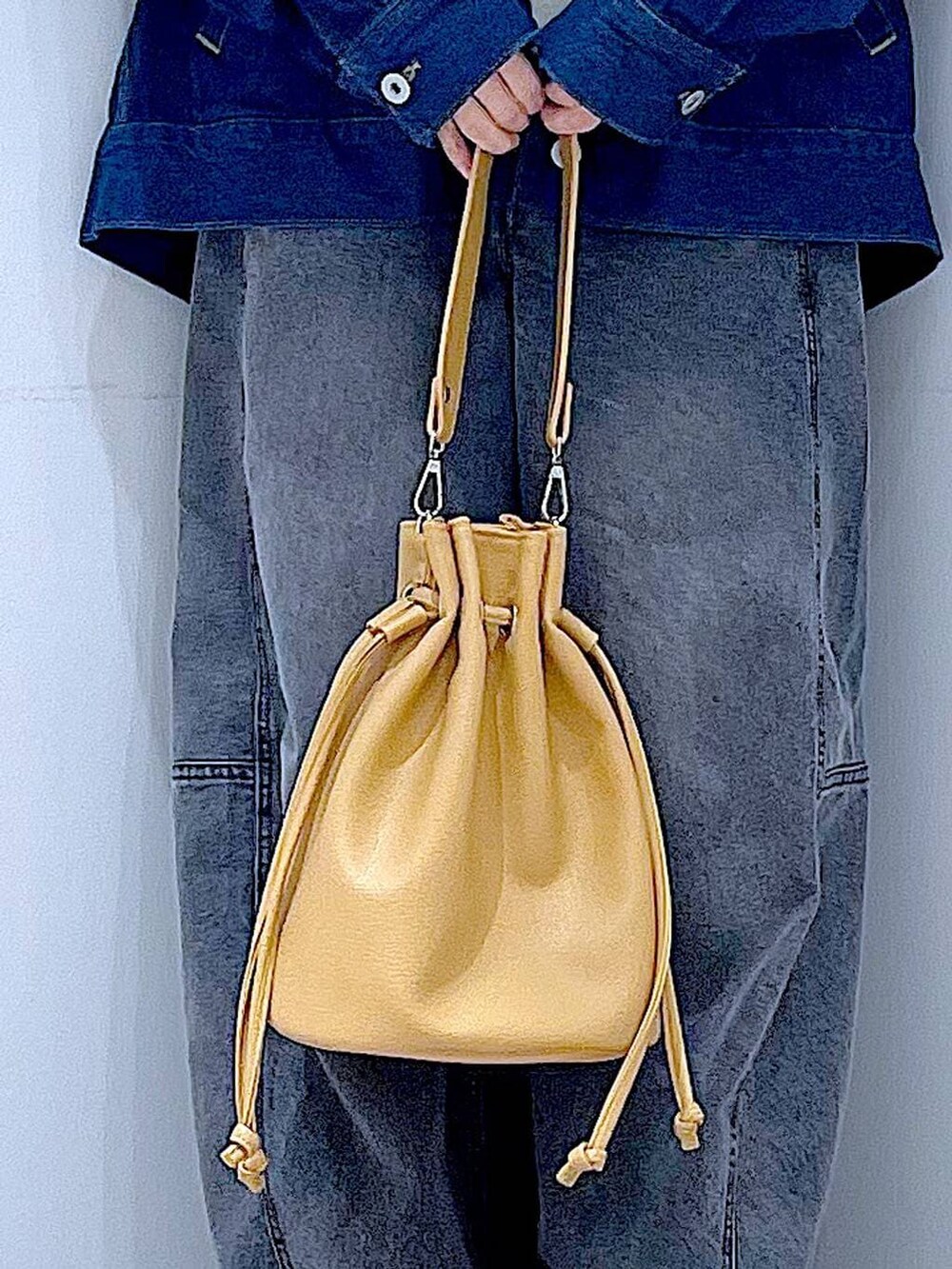 ブルー系のデニムジャケット、ブラック系のデニムパンツ、ブラウン系のショルダーバッグを着用したレディースの春コーディネートの9枚目の写真