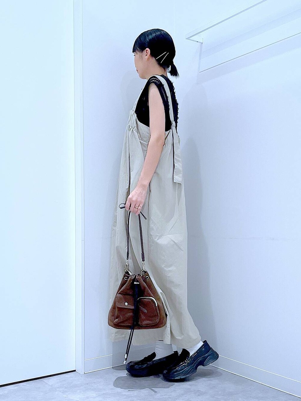 ブラック系のローファー、ブラウン系のショルダーバッグ、グレー系のワンピースを着用したレディースの秋コーディネートの3枚目の写真