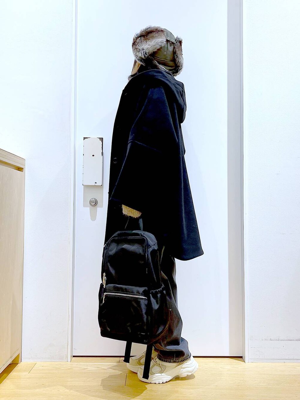 ブラック系のバックパック/リュック、ブラック系のその他アウター、ベージュ系のスニーカーを着用したレディースの冬コーディネートの3枚目の写真