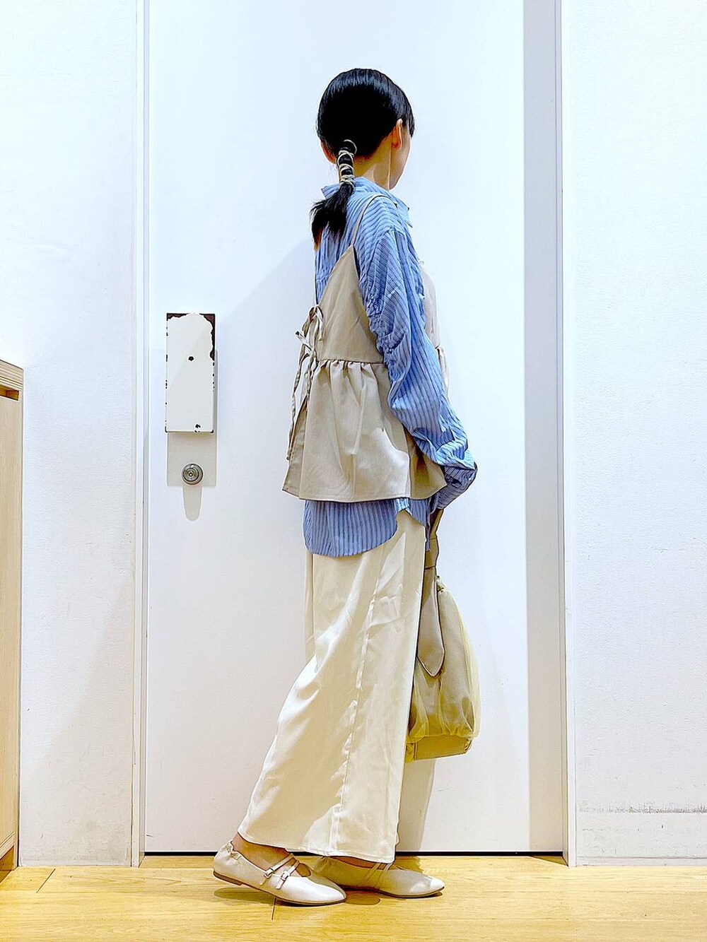 ベージュ系のトートバッグ、ホワイト系のパンプス、ホワイト系のその他パンツを着用したレディースの秋コーディネートの4枚目の写真