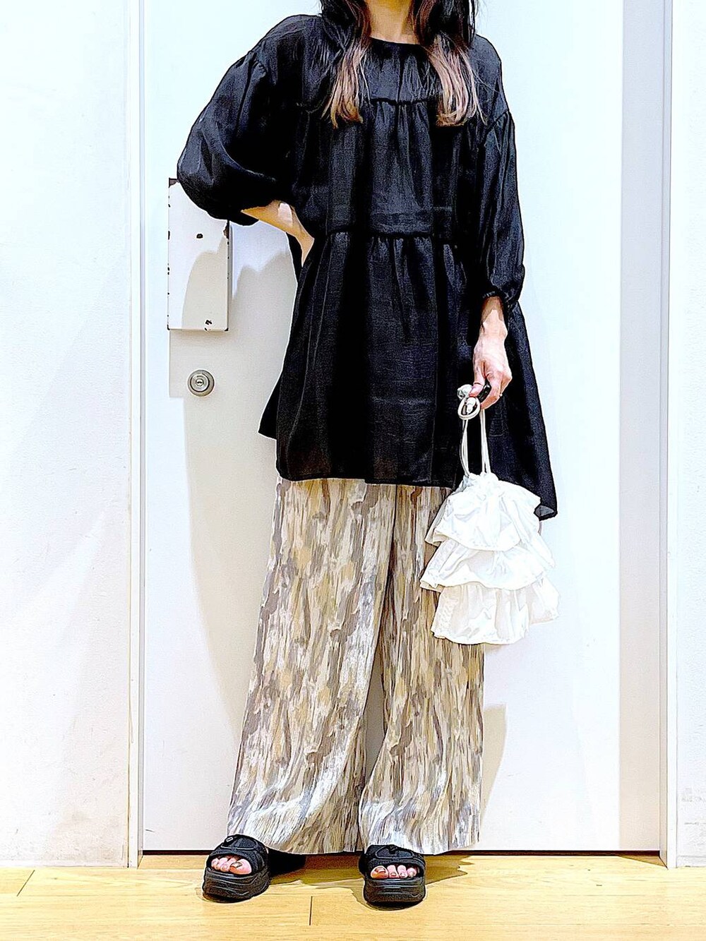 ホワイト系のショルダーバッグ、ブラック系のサンダル、ベージュ系のその他パンツを着用したレディースの夏コーディネートの6枚目の写真