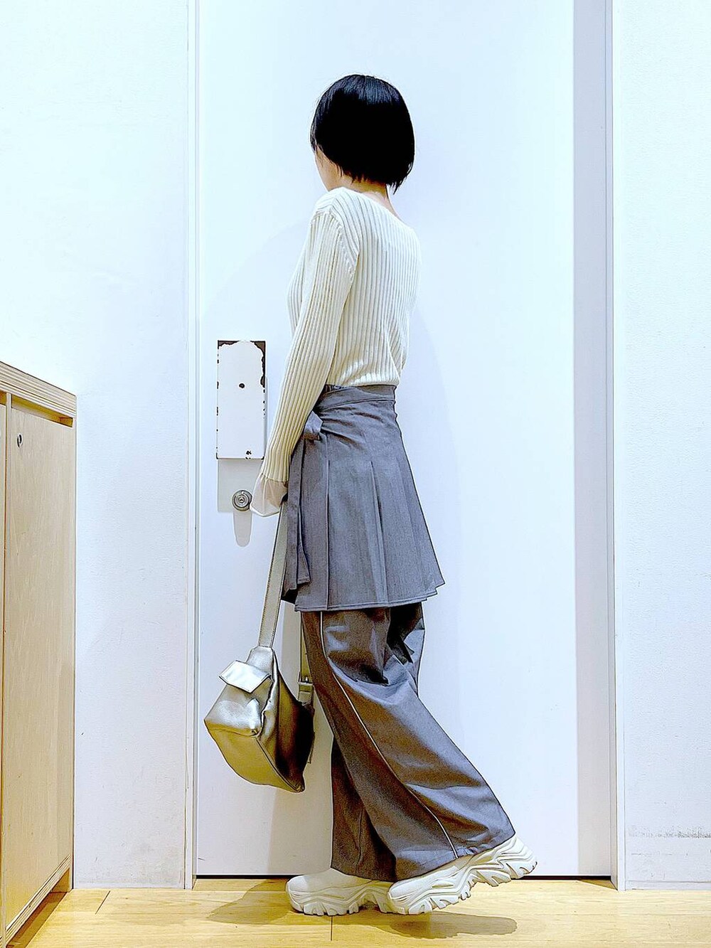 ホワイト系のニット/セーター、グレー系のスラックス、グレー系のスカートを着用したレディースの秋コーディネートの3枚目の写真