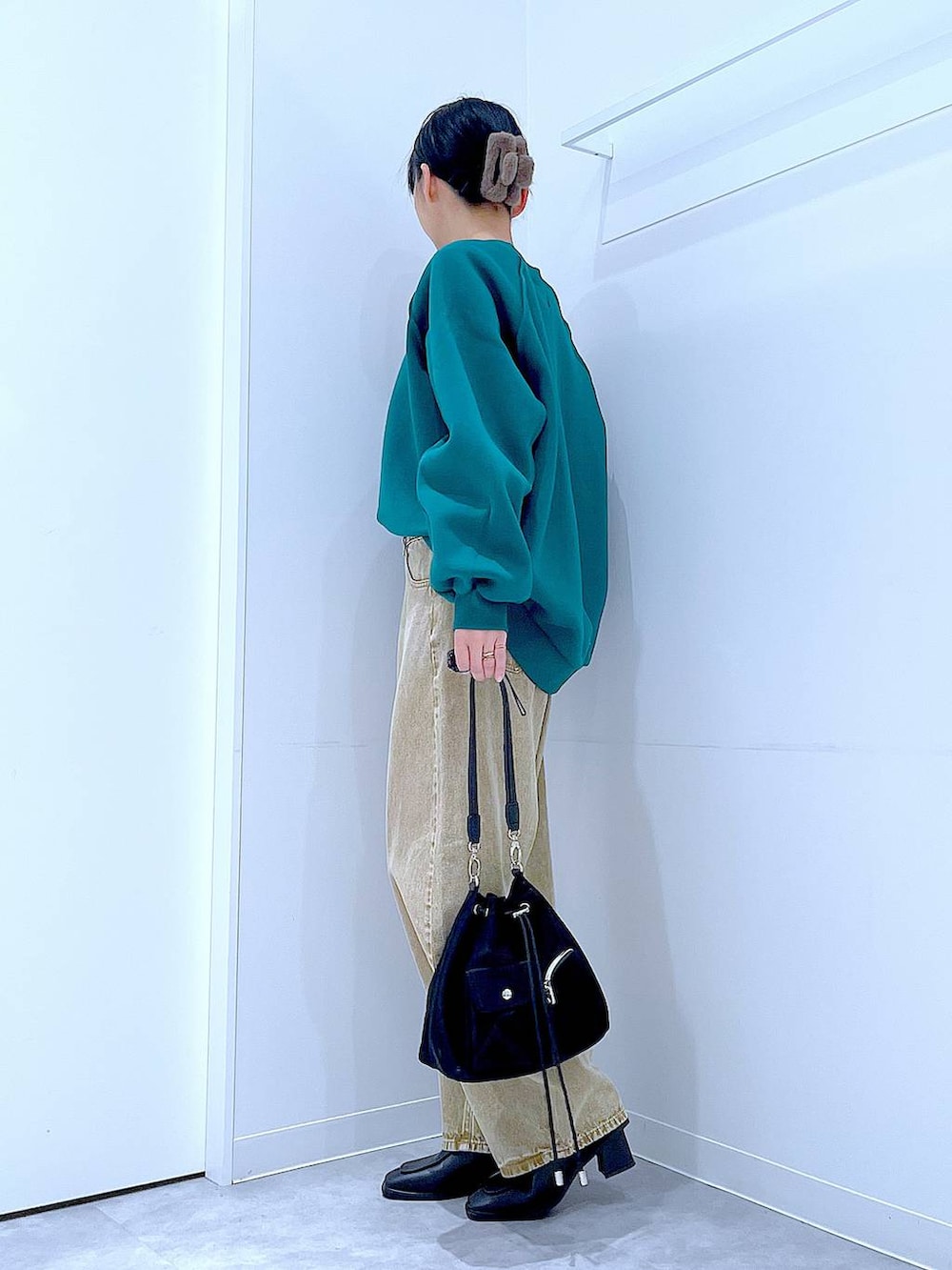 ベージュ系のデニムパンツ、ブラック系のショルダーバッグ、ブラック系のブーツを着用したレディースの冬コーディネートの3枚目の写真