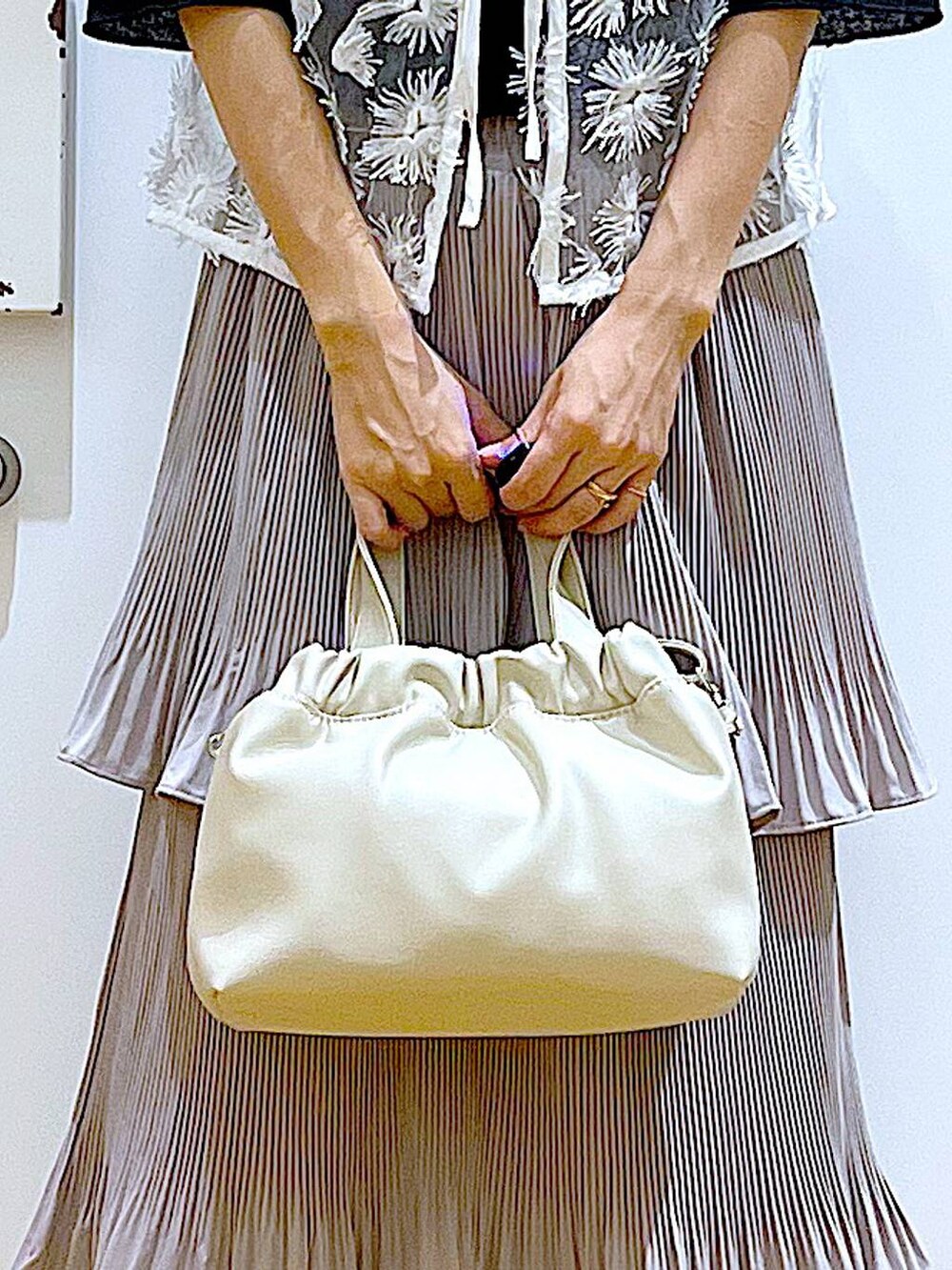 グレー系のスカート、ブラック系のサンダル、ホワイト系のショルダーバッグを着用したレディースの夏コーディネートの9枚目の写真