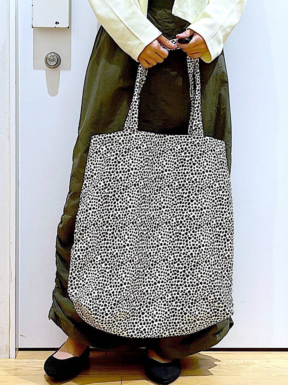 イエロー系のカーディガン/ボレロ、グリーン系のスカート、ベージュ系のトートバッグを着用したレディースの春コーディネートの9枚目の写真