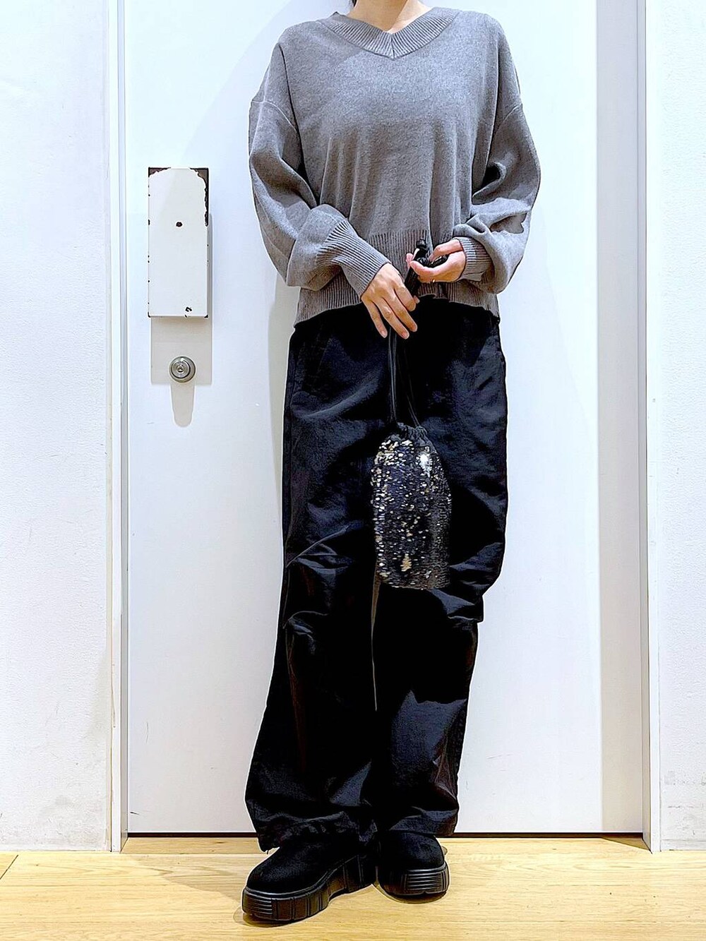 ブラック系のショルダーバッグ、ブラック系のブーツ、ブラック系のその他パンツを着用したレディースの冬コーディネートの6枚目の写真