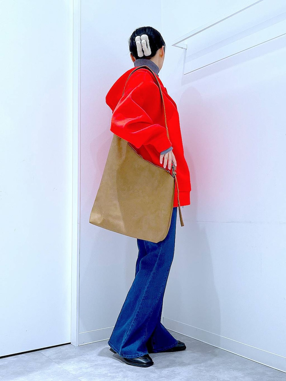 レッド系のパーカー、ブラック系のブーツ、グレー系のニット/セーターを着用したレディースの冬コーディネートの4枚目の写真